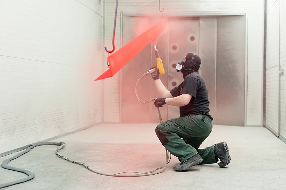 man applies powder coating, a coating method alongside dip-spin coating at coating systems
