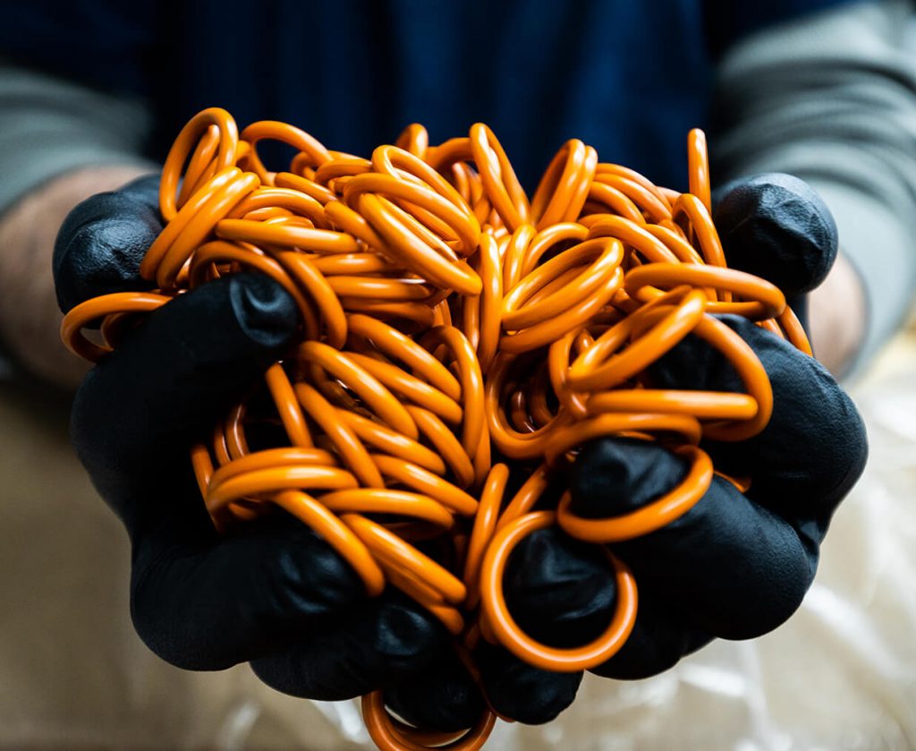 hands holding lots of orange o rings