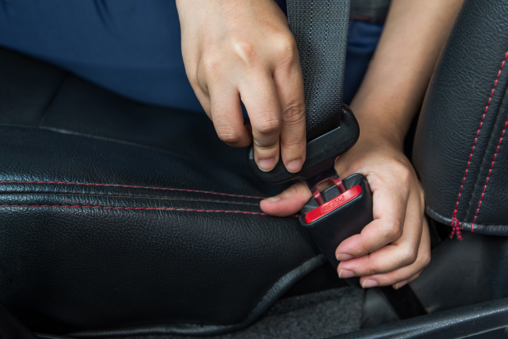 Woman fastening a car seat belt